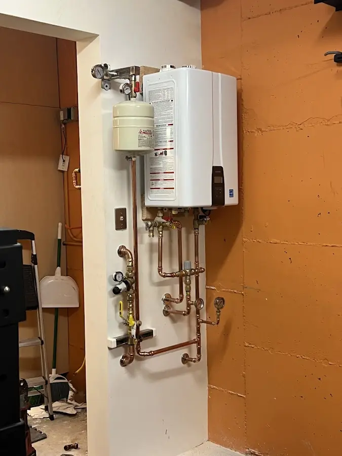 Plumbing technician inspecting water heater connections in Watergate